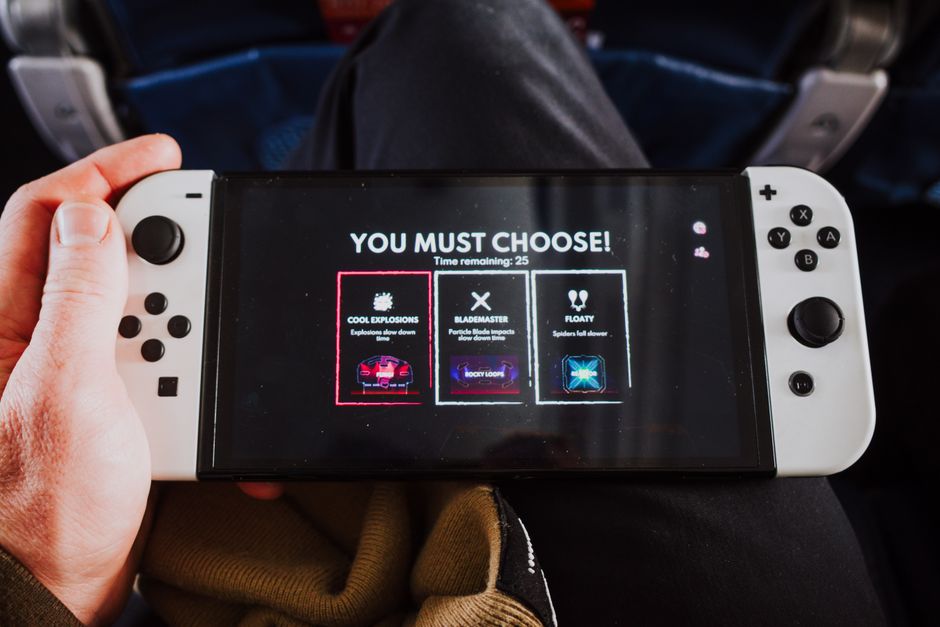 Close-up of a person holding a gaming console with an on-screen decision prompt.