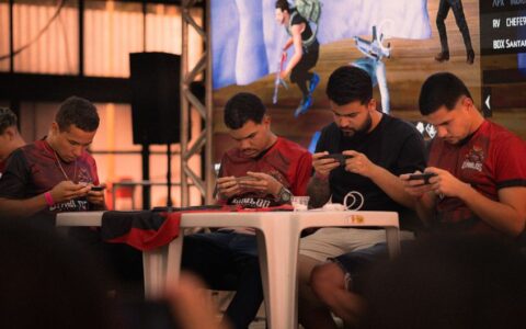 Group of gamers intensely focused during a mobile e-sports tournament indoors.